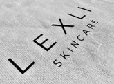 close-up of white knit cloth with Lexli Skincare logo